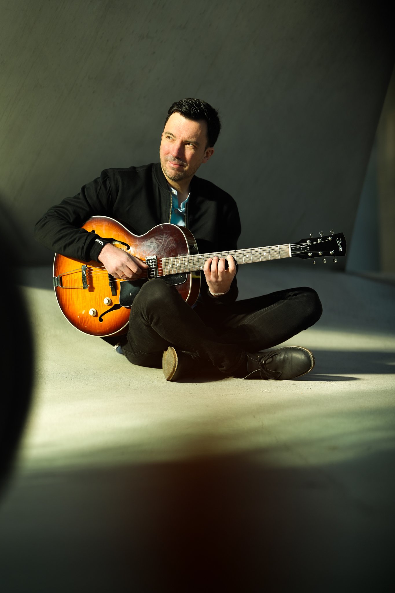 Vincent Rocher sitzend mit Gitarre